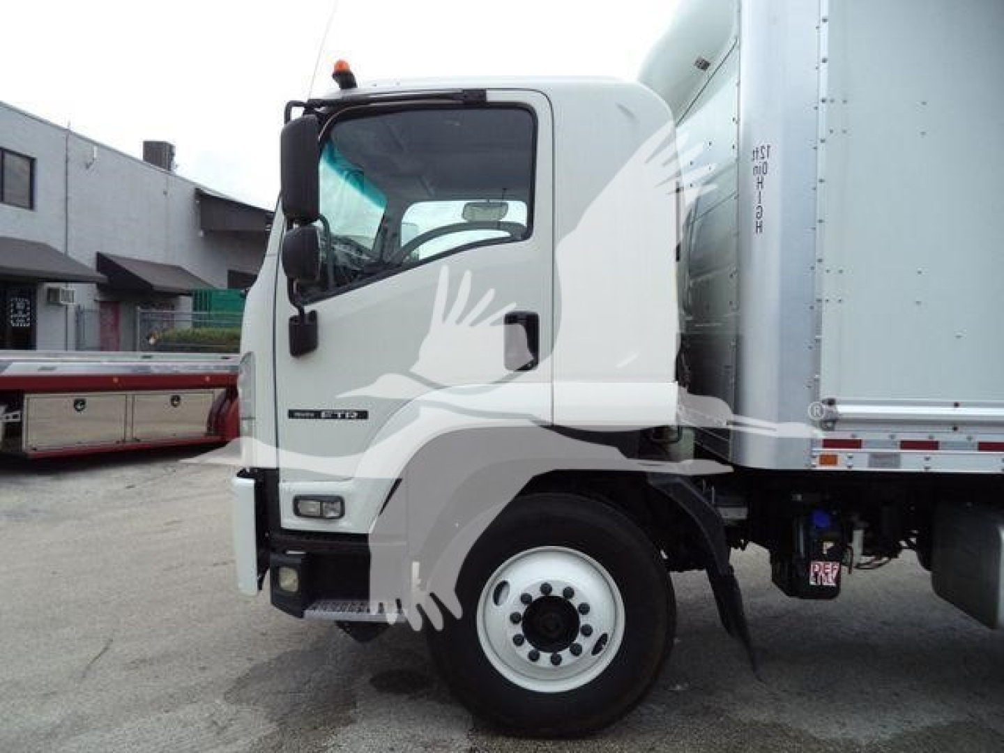 Isuzu NPR truck cab and box side view showing wheel and front door with logo