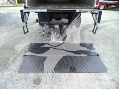 Isuzu box truck rear view showing liftgate extended, with metal platform and hydraulic components visible under cargo area.