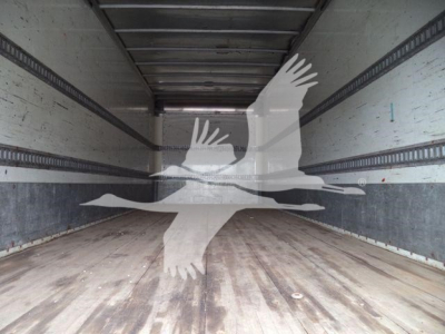 Inside semi-truck box showing empty cargo area with wooden floor and sidewall rails.