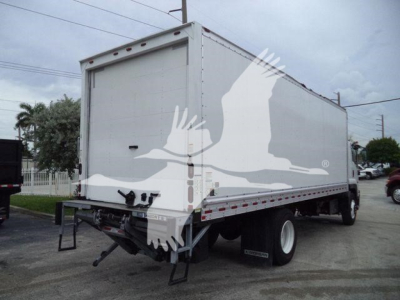 Isuzu box truck rear view showing plain white cargo box, rear doors closed, with bumper and hitch area visible.