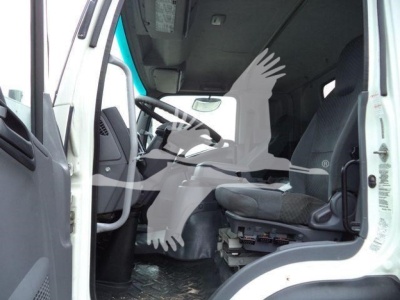 Isuzu FTR truck cab interior showing driver's seat and steering area from open door, with floor mats and control panel visible.