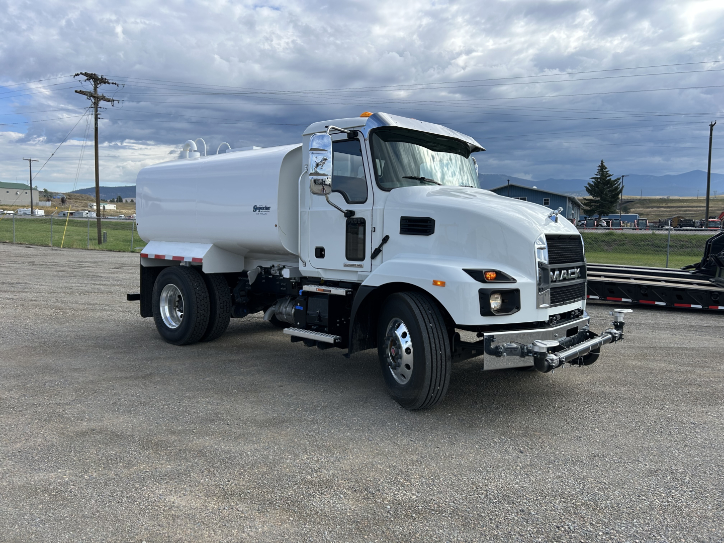 Water truck/ tanker truck showing front and side view with Mack MD7 cab and white tank, VIN 1M2MDBAA4SS075893 visible on listing.