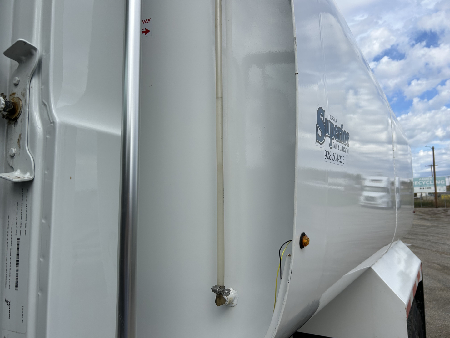 Truck trailer side showing vertical rail and hydraulic line with Shield brand logo and reflective surface