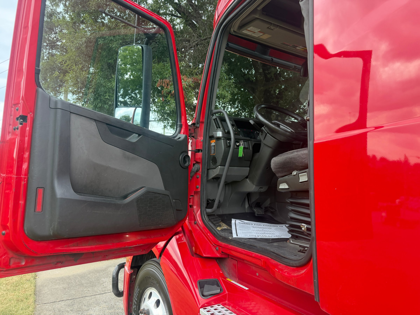 Volvo VNL64T760 truck cab interior and open door showing steering wheel and dashboard.