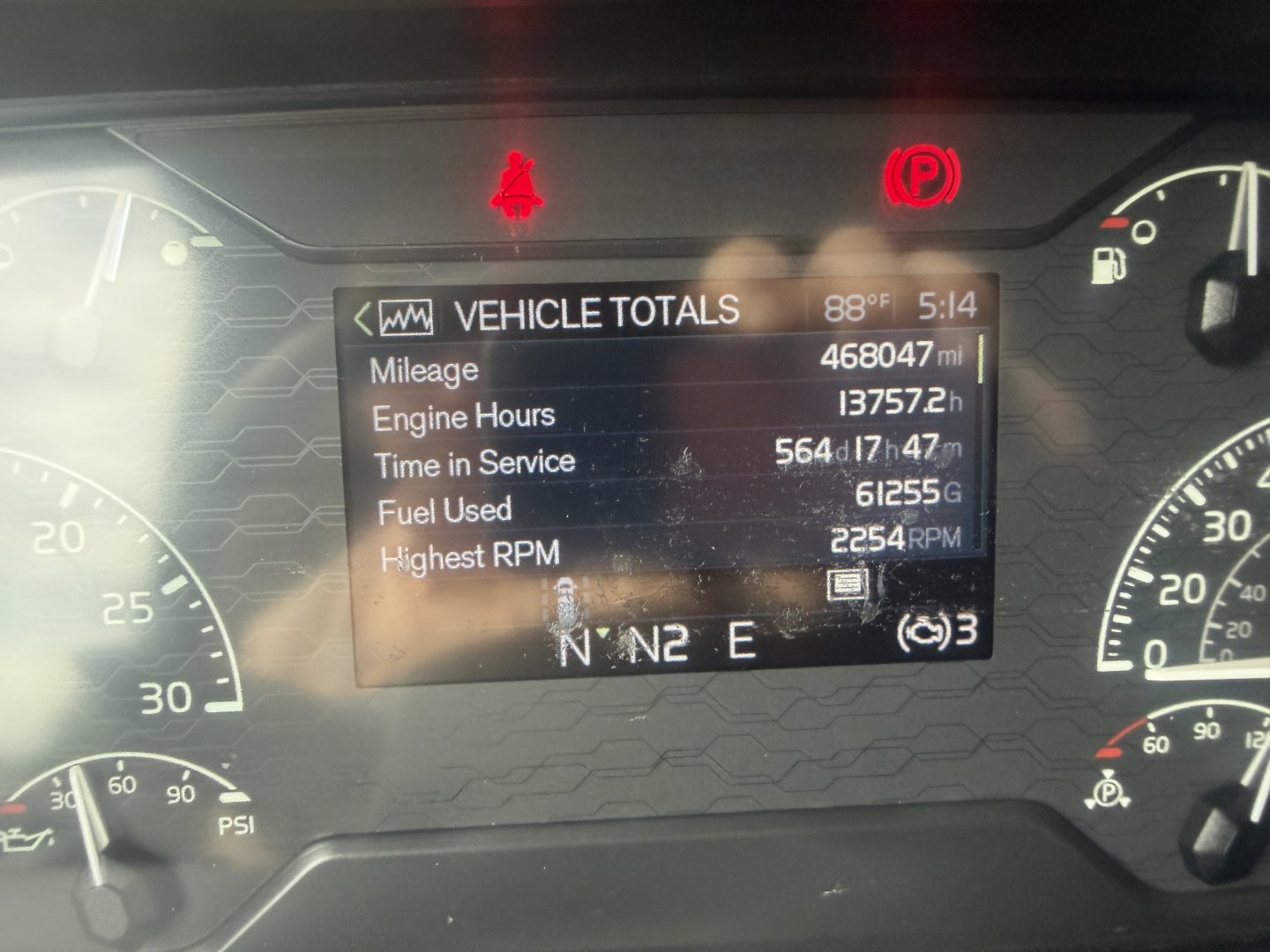 Volvo VNL64T760 dashboard display showing vehicle totals including mileage 468047 mi, engine hours 13757 h, time in service 564 days, fuel used 61255 gal, highest RPM 2254 on screen.