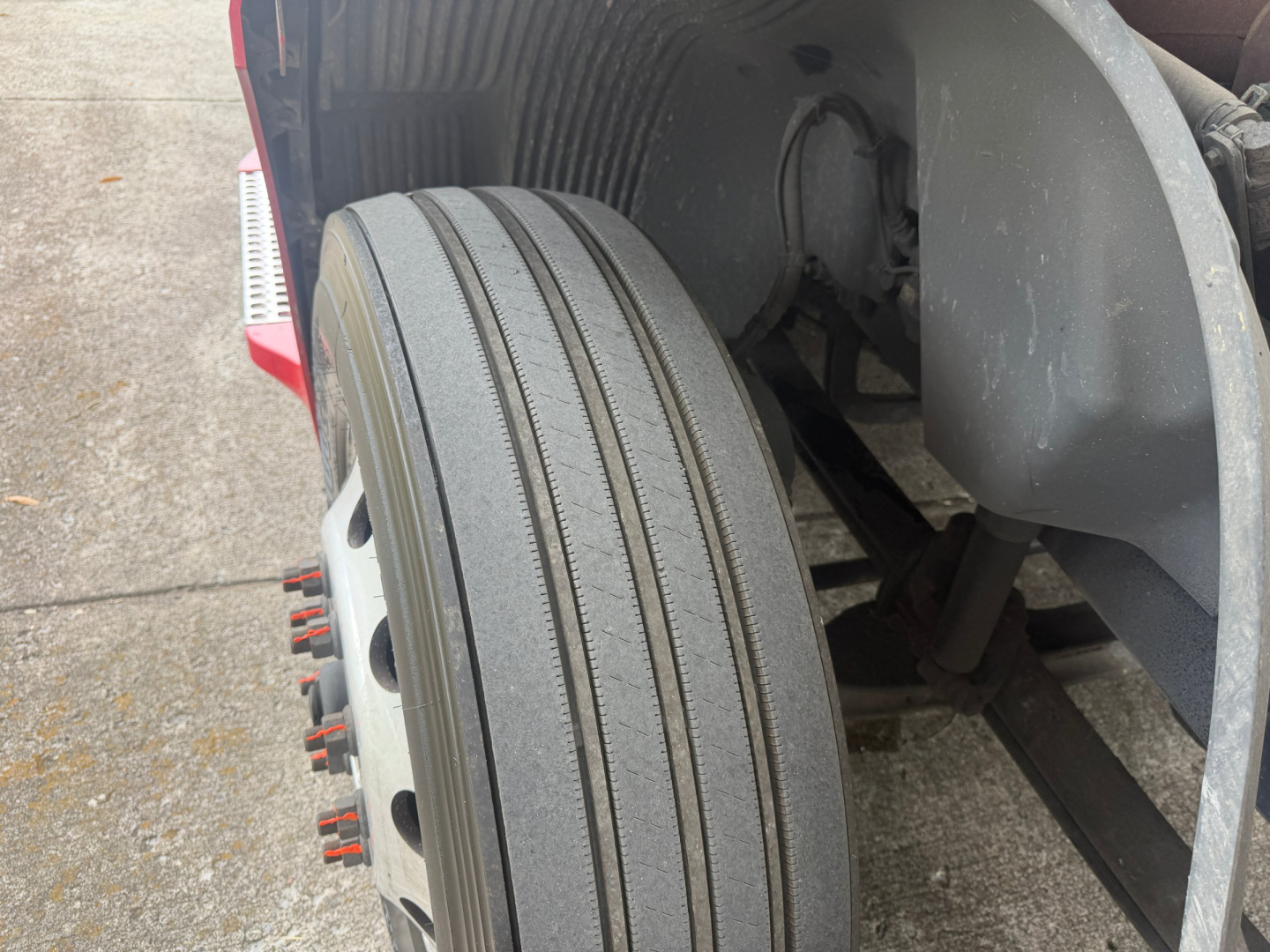 Volvo VNL64T760 truck front wheel and fender view showing dual-rear tires and wheel hub area.