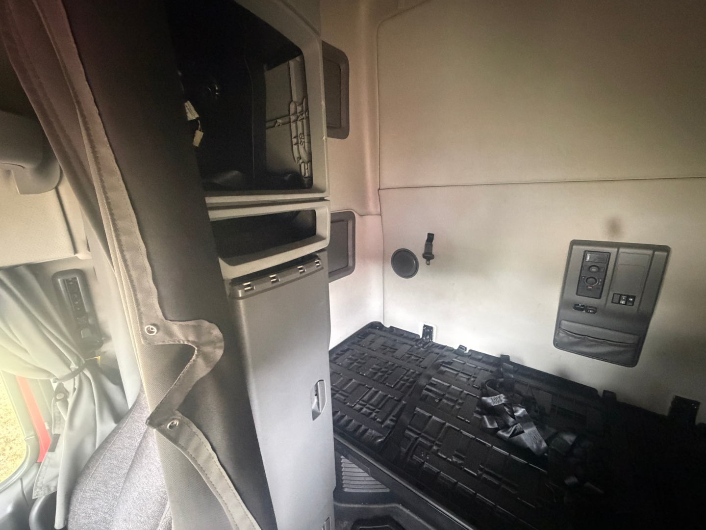 Volvo VNL64T760 sleeper cab interior showing side panel, control switches, and floor mat.