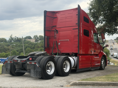 Volvo VNL64T760 sleeper tractor rear/side view showing chassis with dual rear axles and red cab.