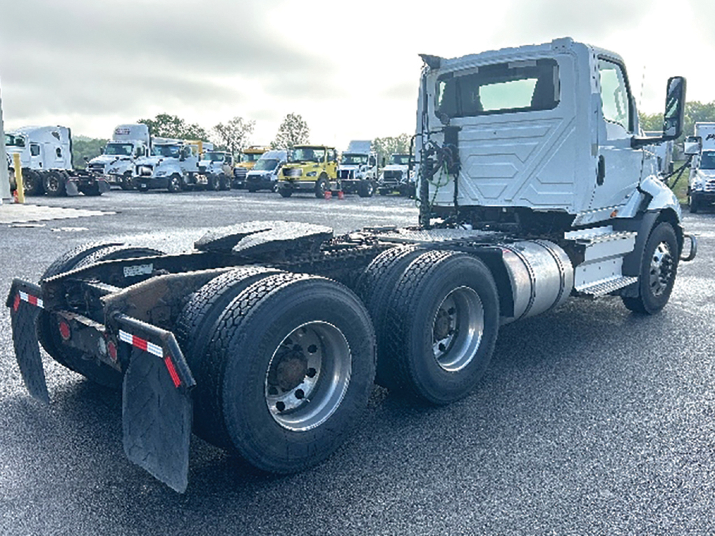 Truck cab and chassis of a 2019 International RH613 conventional daycab showing rear triple-axle configuration and fuel tanks.