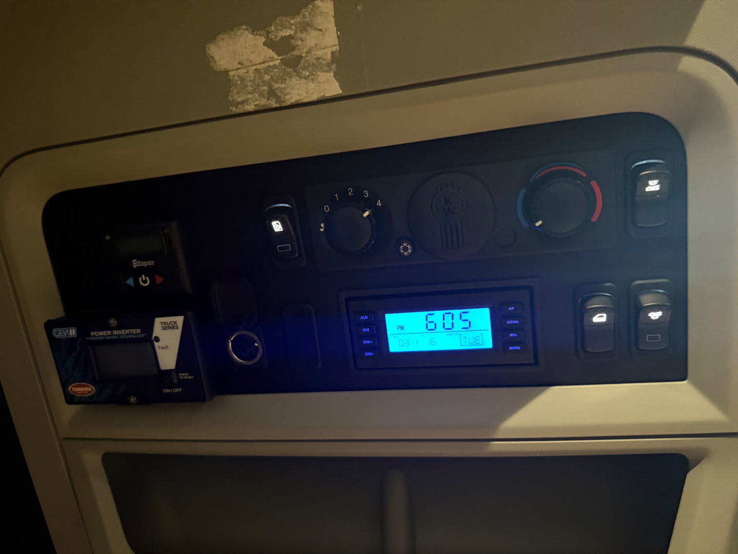Kenworth truck cab dashboard showing digital gauge and climate controls.