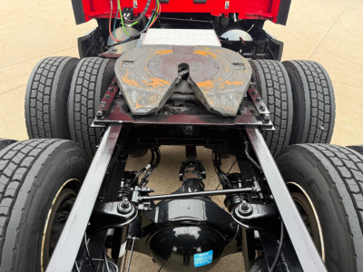 Rear view of a Kenworth T680 chassis showing fifth wheel, dual rear axles, driveshaft, suspension, and frame with visible air/brake lines.