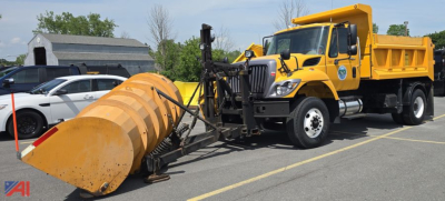 International WorkStar 7500 dump truck with front plow and snow bucket attachment in a parking lot.