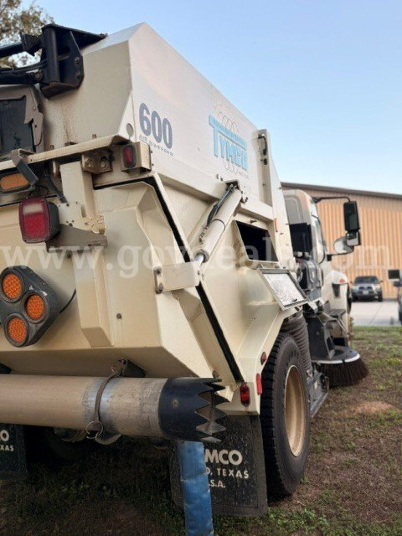 Dump truck bed of a 2016 International 4300 with hydraulic tipping system and spare tire mount visible.