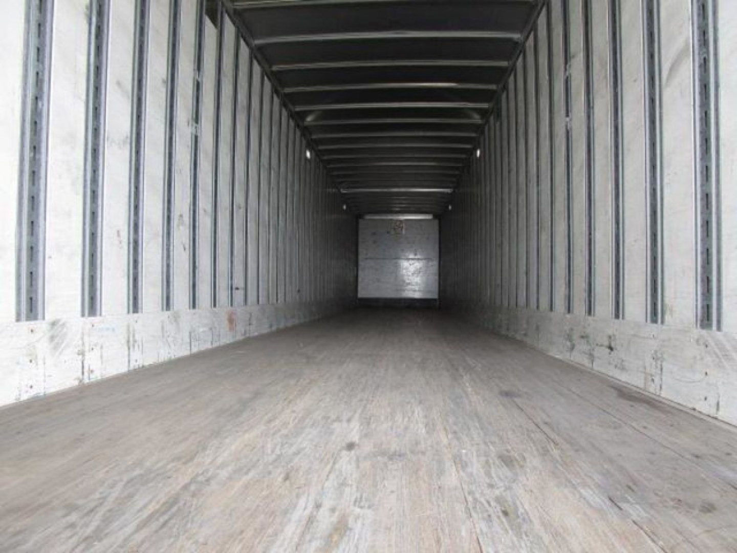 Interior of a used 2014 Stoughton van trailer with empty cargo space, steel walls, wooden floor, and rear opening