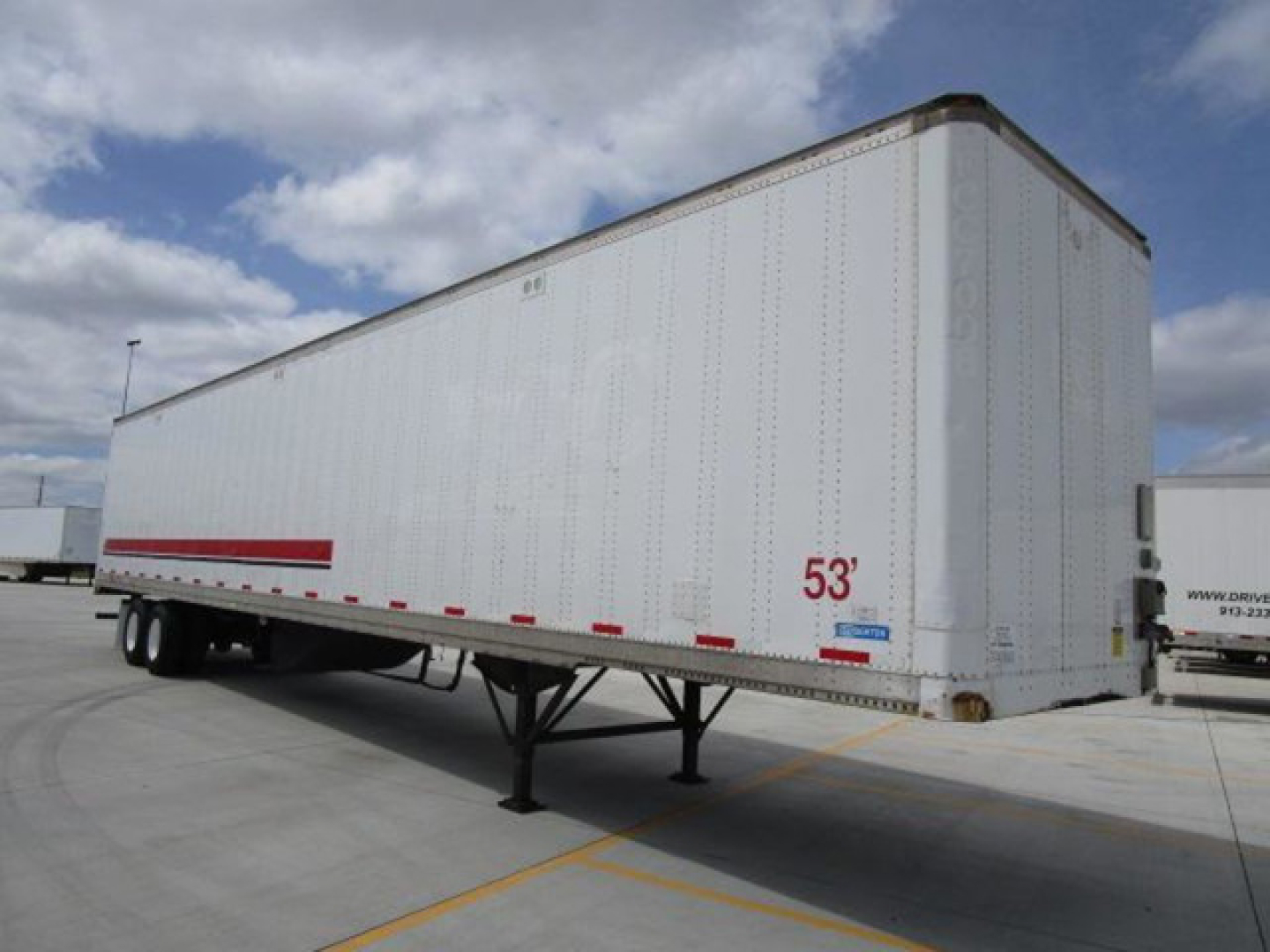Stoughton 53' dry van trailer in a parking lot, side view showing '53'' marking and rear door area.
