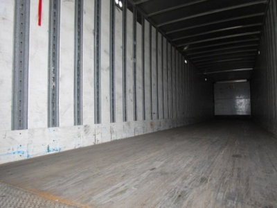 Interior of a 2014 Stoughton van trailer in empty trailer space showing wooden floor and metal side walls.
