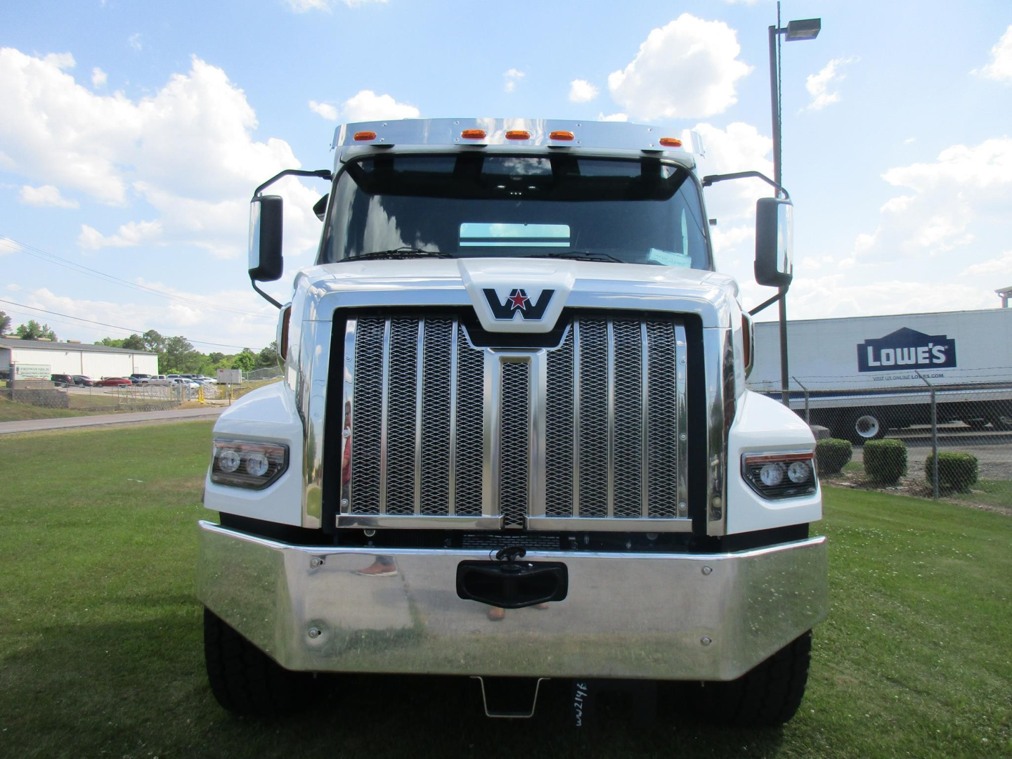 Front view of a 2026 Western Star 47X roll-off truck showing chrome grille, headlights, and bumper.