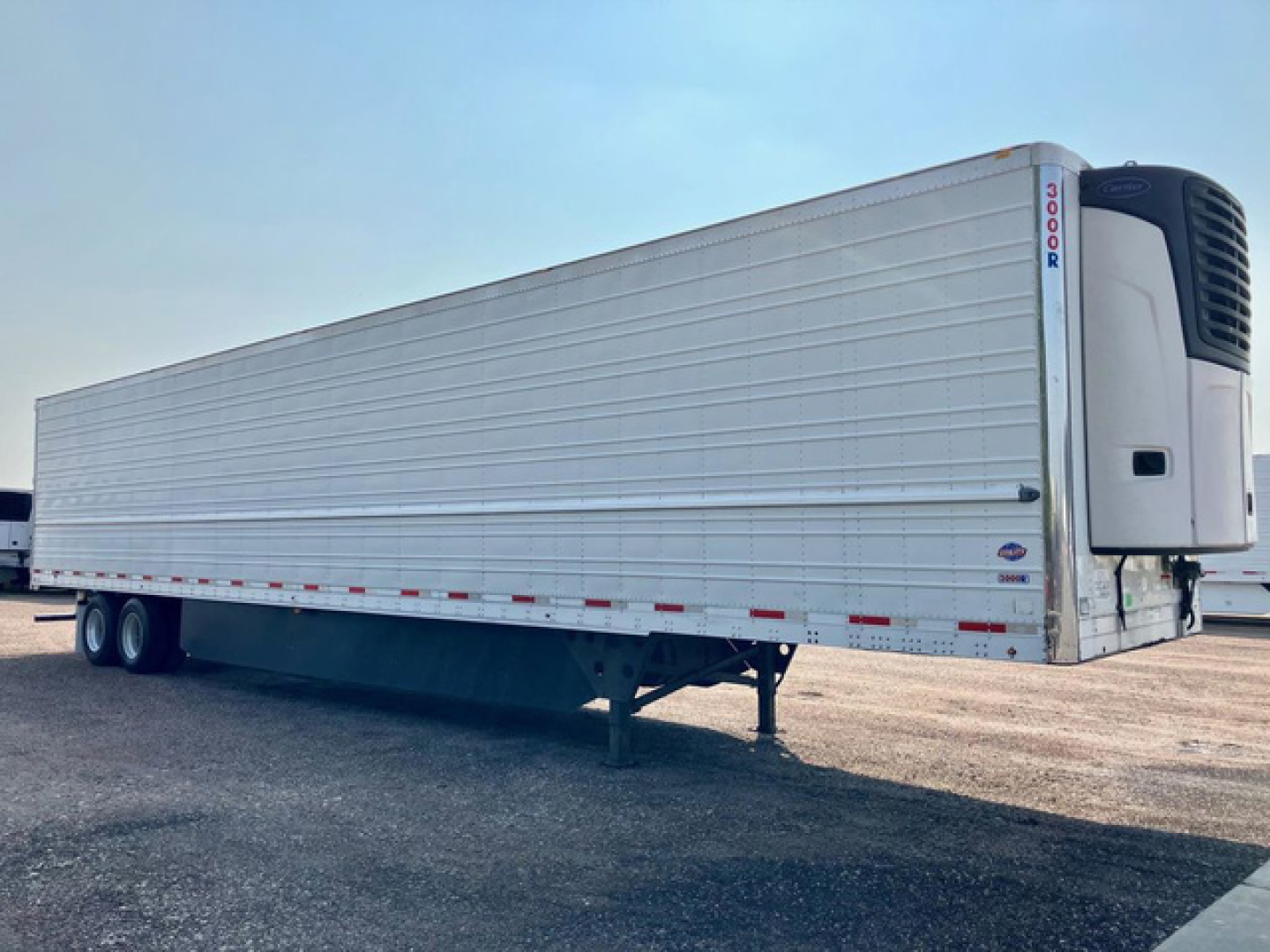 Utility reefer trailer with a refrigerated unit at the front showing a clean silver metal exterior and dual rear wheels.