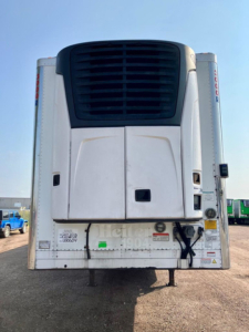 Rear view of a used 2019 Utility refrigerated trailer with a white body, black vent/grille at top, docking area, and various labels on the rear doors.