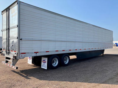 Utility reefer trailer showing side view with tandem wheels and rear doors