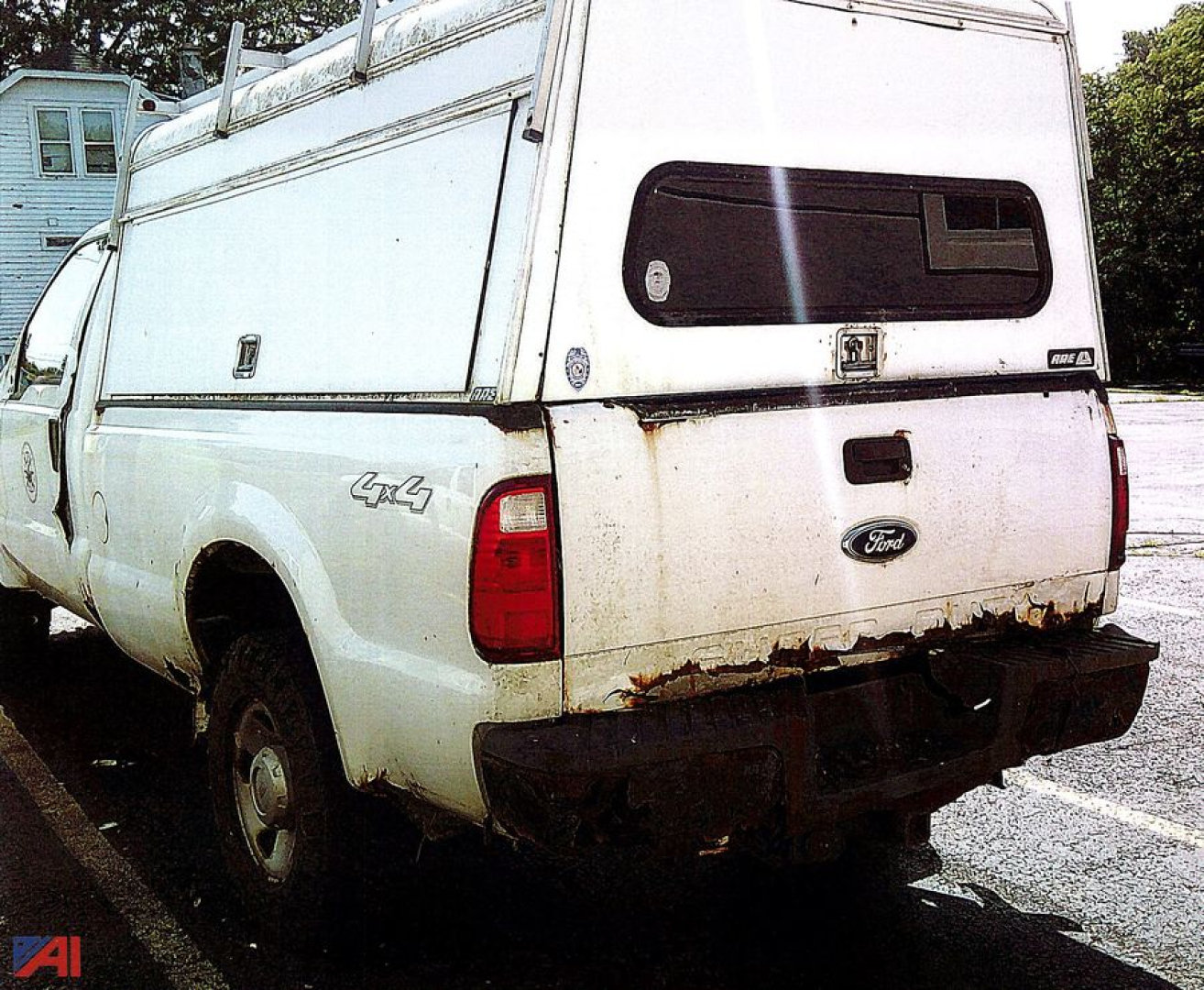 Ford F-250 Super Duty pickup with a white camper shell, rear 4x4 badge, and visible rust along the bumper area.