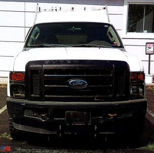 Ford F-250 Super Duty front view showing white truck with black grille and box cover in a parking lot.