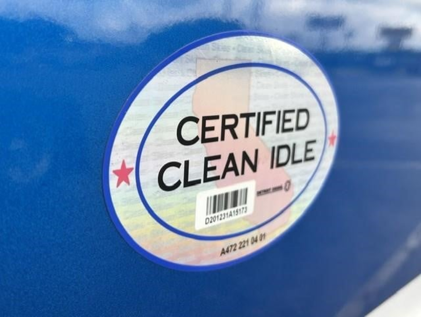 Sticker label reading CERTIFIED CLEAN IDLE with barcode on blue truck exterior.