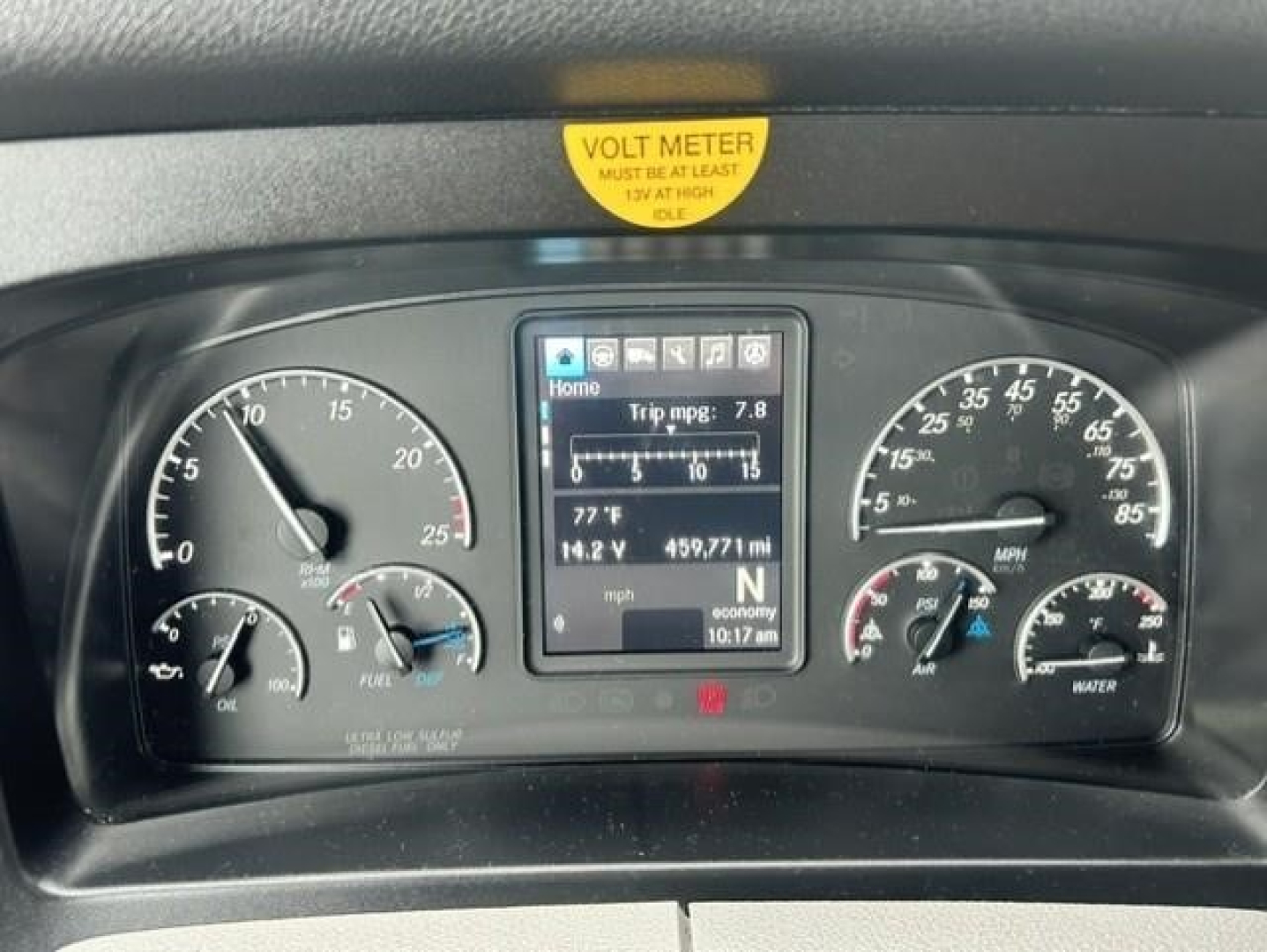 Dashboard of a Freightliner Cascadia 126 showing instrument cluster with digital display, gauges for speed, RPM, fuel, and coolant; yellow VOLT METER decal at top.