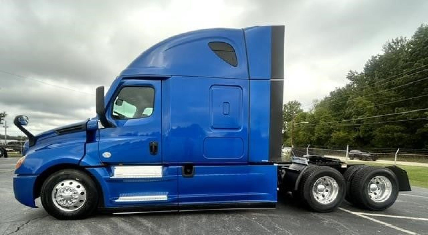Freightliner Cascadia 126 tractor in blue side view showing sleeper cab and rear dual axles.
