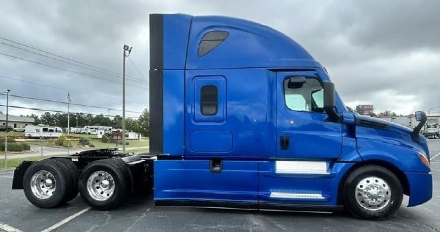 Freightliner Cascadia 126 sleeper cab side view showing blue exterior and twin rear axles.