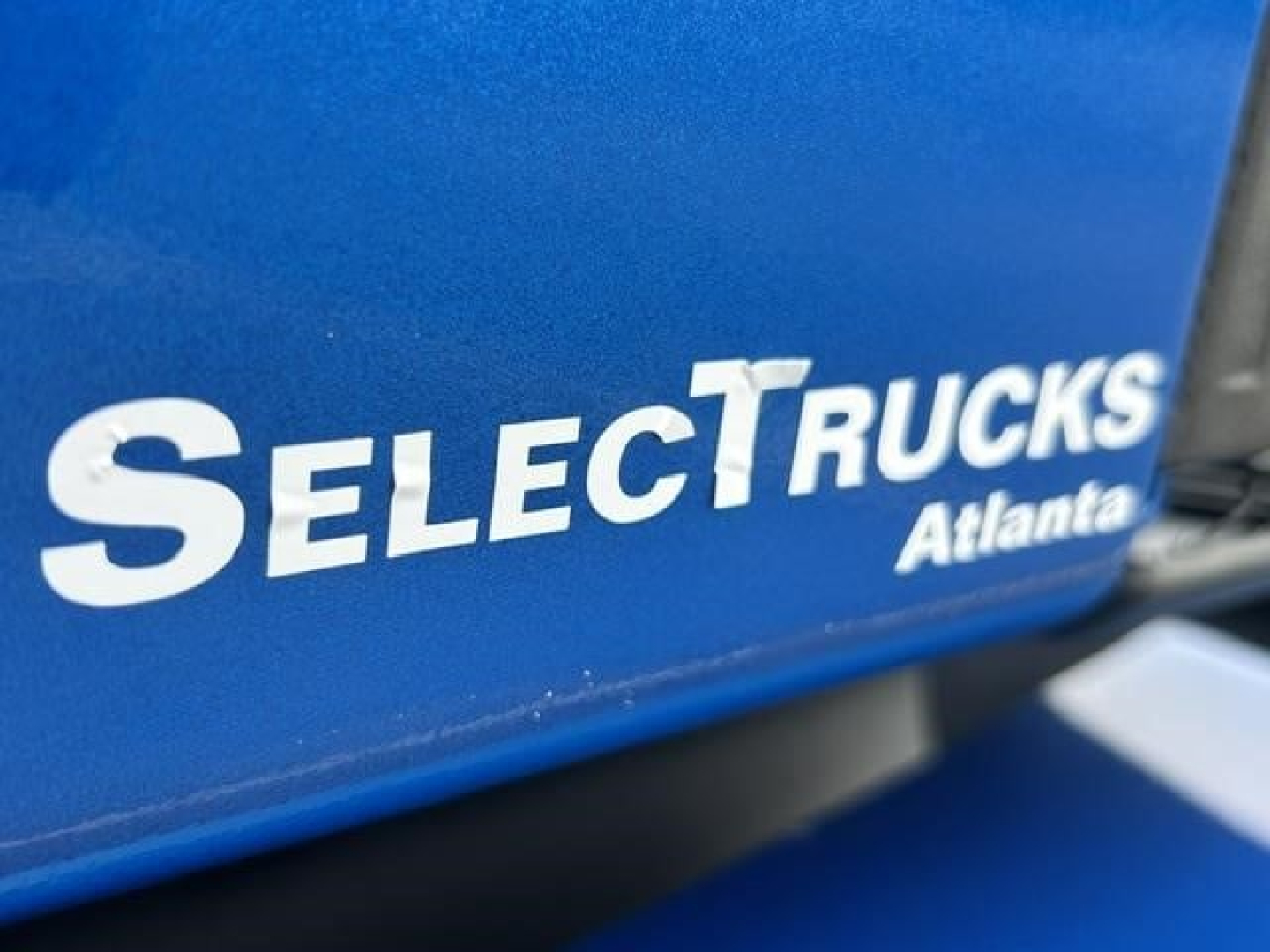 SelectTrucks Atlanta showing a blue truck part with white 'SelectTrucks Atlanta' logo.