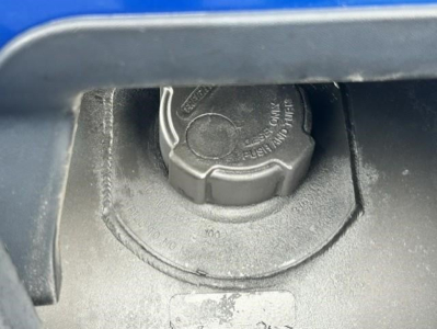 Freightliner Cascadia engine bay showing a circular power steering/ coolant cap with textured grip and embossed text
