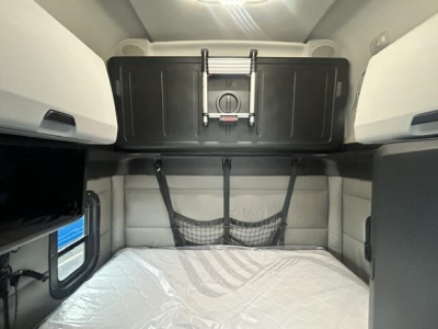 Freightliner Cascadia sleeper cabin with overhead storage and bed; no legible labels visible on the bed area