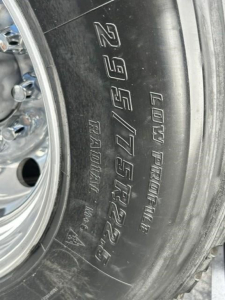 Tire sidewall showing 11R22.5? Not sure. The visible text: L0t? 'Low Pro...?' The tire reads 'LUD? PATENT' and 'RADIAL TUBELESS' plus '275/...'.