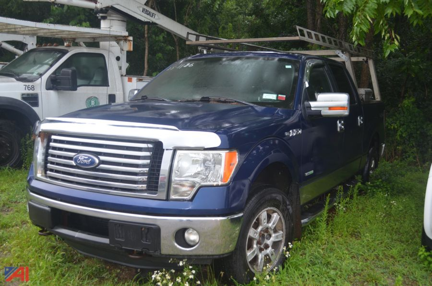 2011 Ford F-150 Crew Cab 4x4 pickup truck in blue with chrome grille and bumper, front three-quarter view.