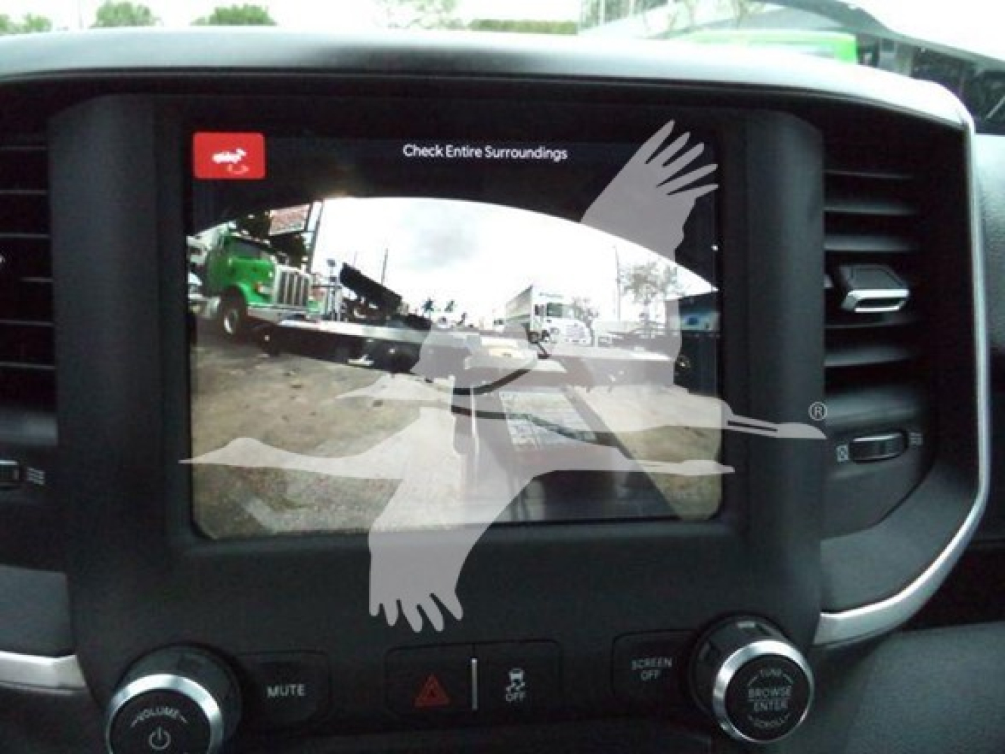 Ram 5500 dashboard display screen showing backup camera view with parking lines and vehicle icons, inside cabin center console.