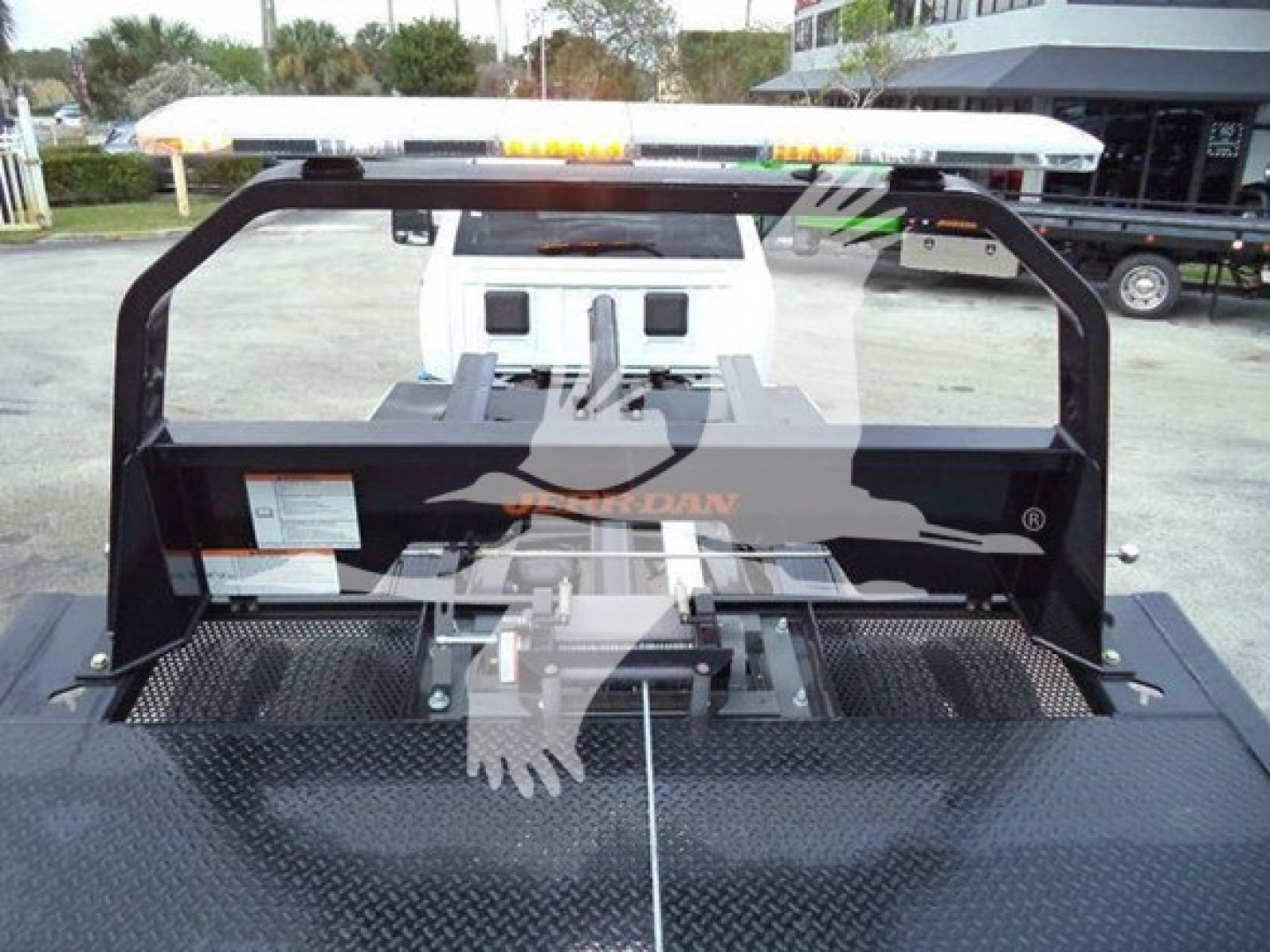 Ram 5500 rollback bed showing heavy-duty frame and winch assembly with metal diamond plate surface and mounting hardware