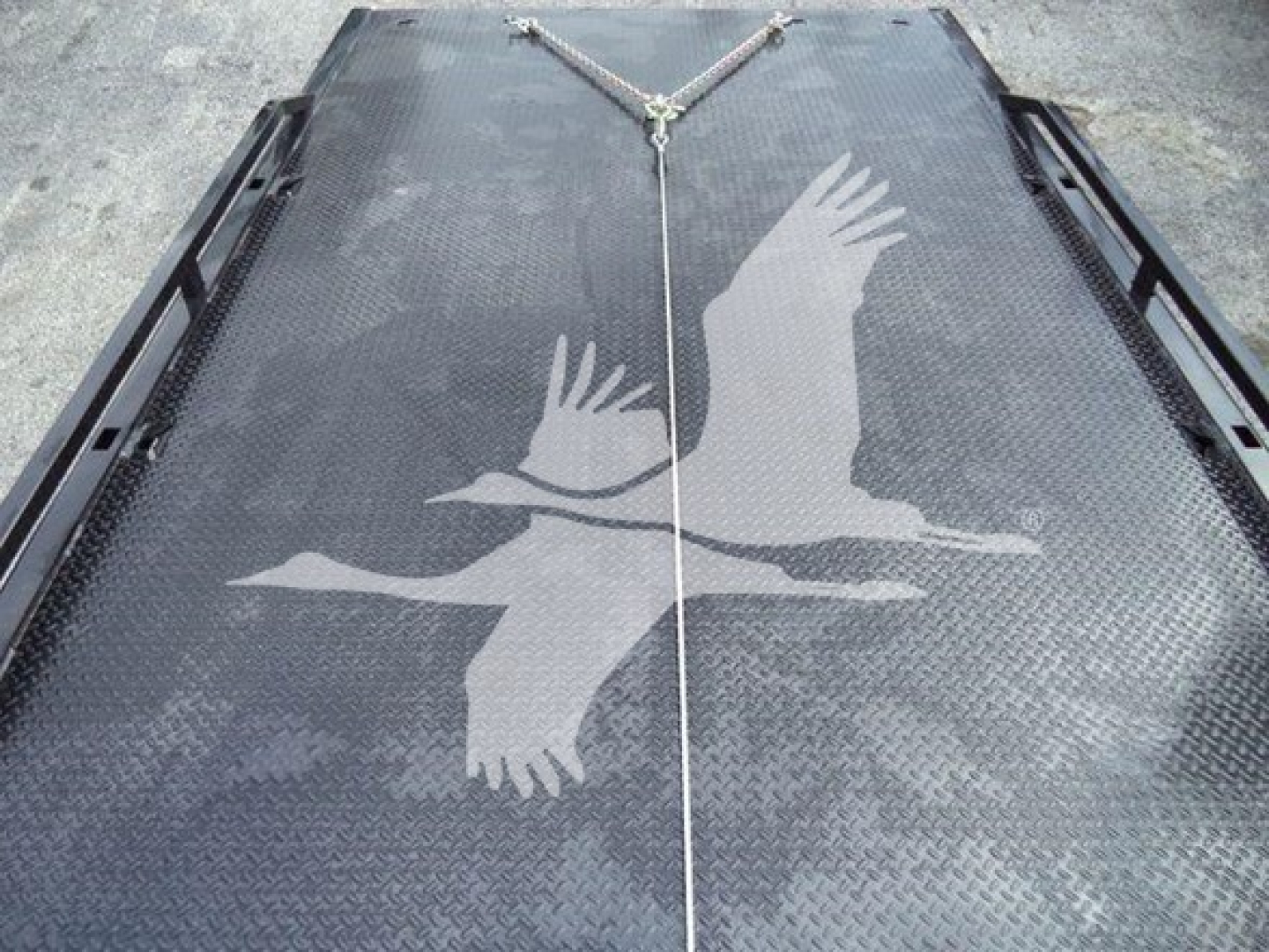 Ram 5500 rollback bed platform with graphic of two birds in flight on diamond plate surface