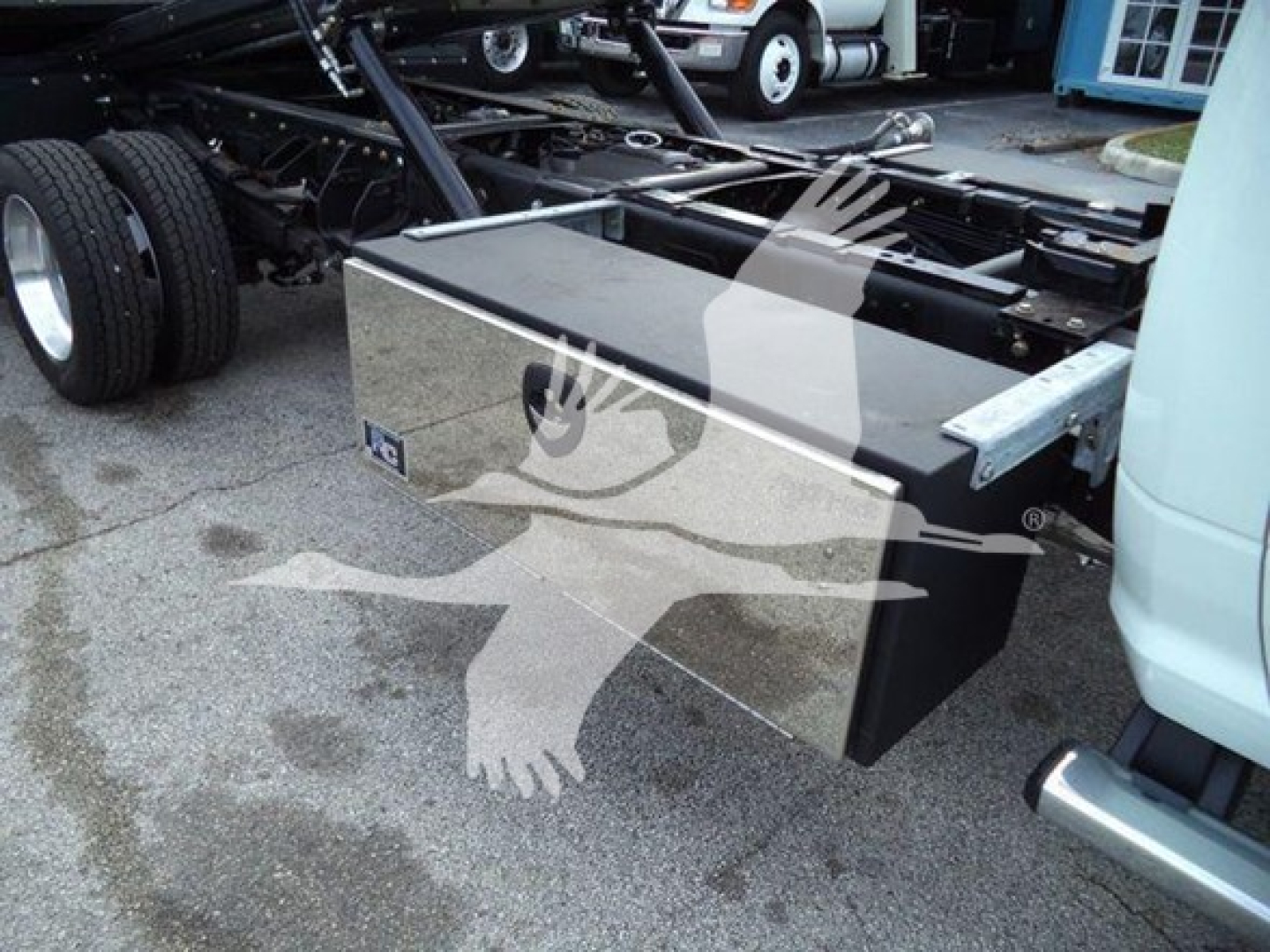 Truck rollback bed with aluminum toolbox mounted under cab旁 visible on a Ram 5500 chassis