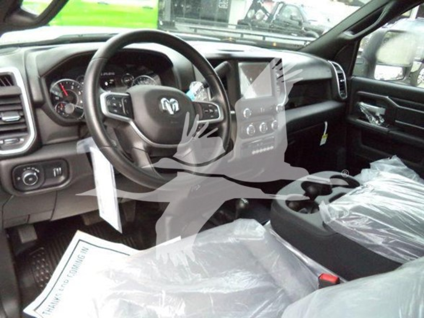 Ram 5500 SLT interior showing steering wheel with Ram logo, center infotainment display, dashboard, and plastic-covered seats.