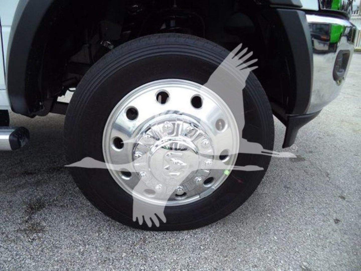Wheel and front axle of a RAM 5500 truck showing a polished chrome hubcap and black tire.