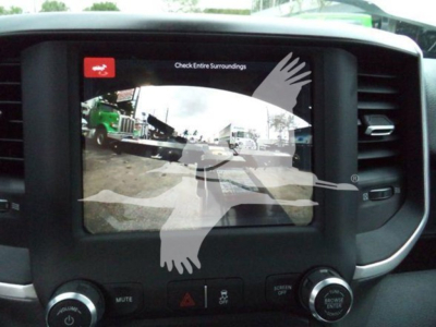 Ram 5500 dashboard display screen showing backup camera view with parking lines and vehicle icons, inside cabin center console.