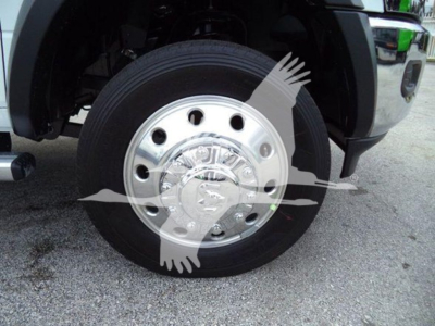 Wheel and front axle of a RAM 5500 truck showing a polished chrome hubcap and black tire.
