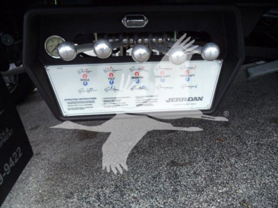 Truck toolbox with control levers and gauges; label shows Jerr-Dan, warning/operating instructions, and multiple control switches.