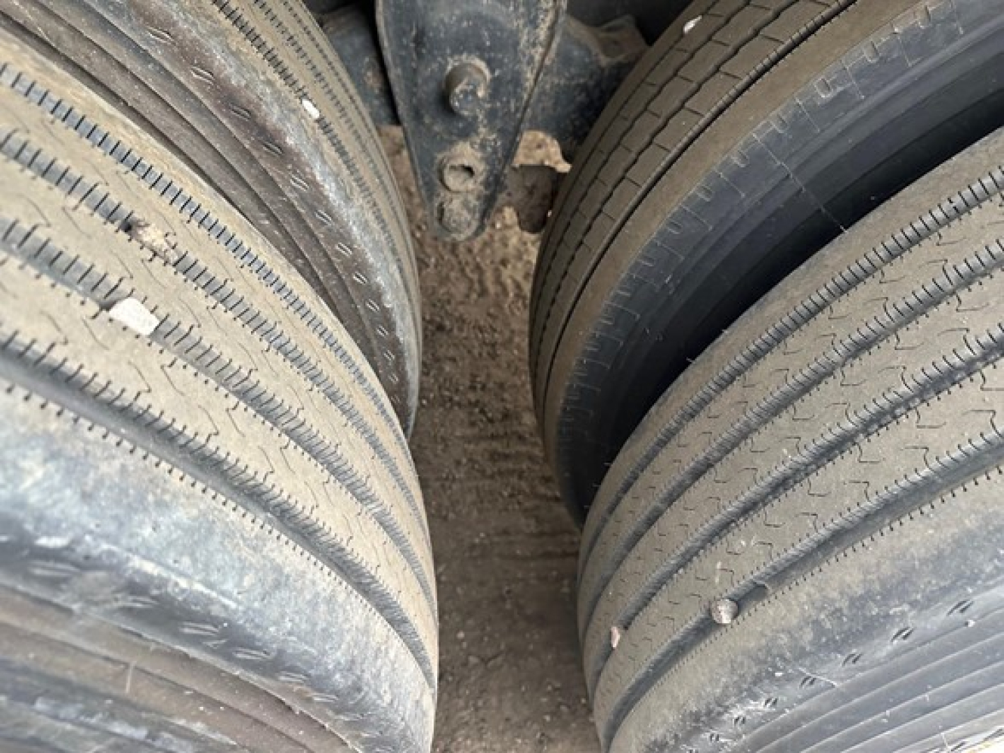 Trailer tires (dual wheels) on Fontaine Velocity flatbed trailer showing tread; part of undercarriage and frame visible.