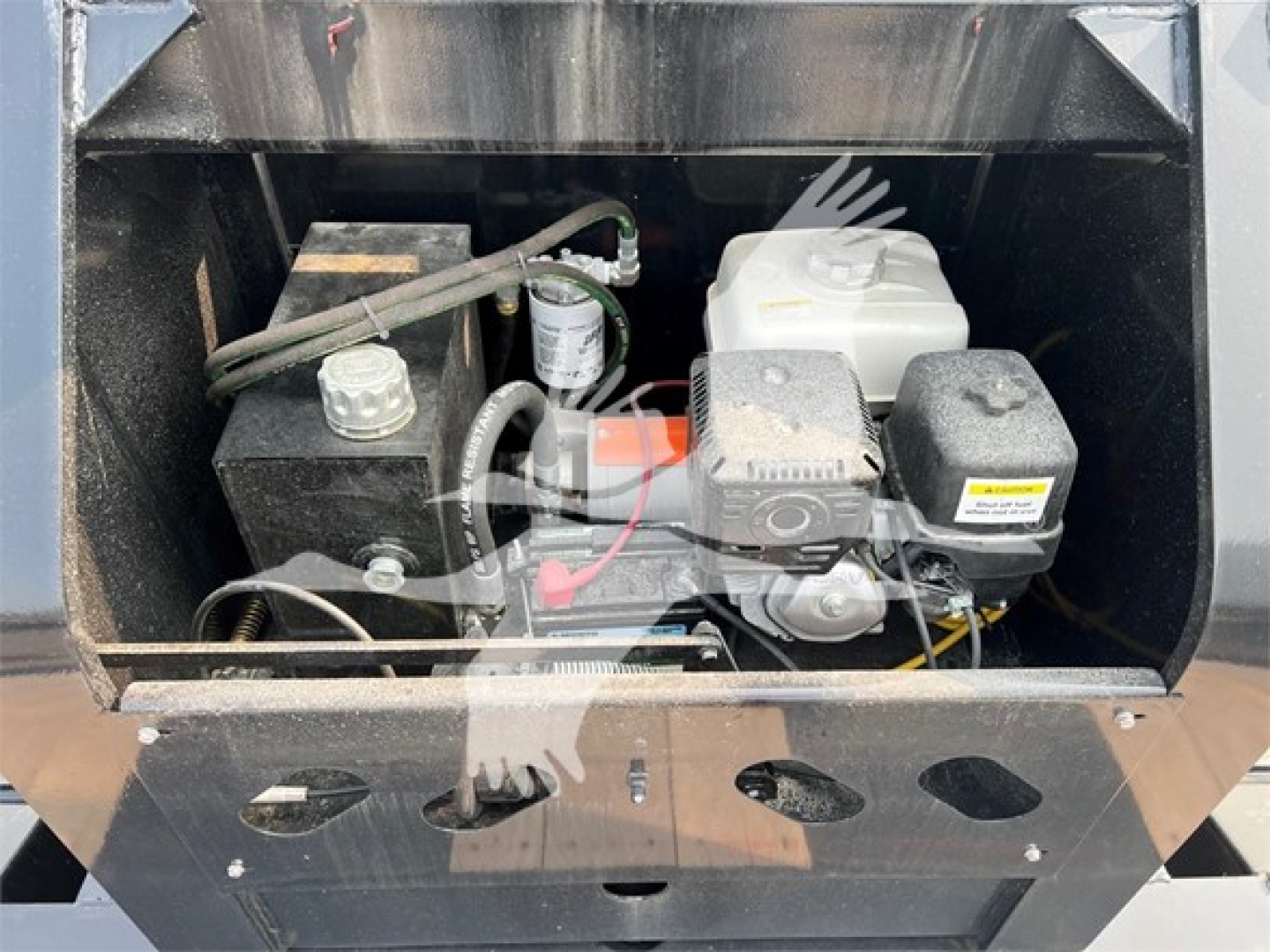 Trailer engine bay showing small gasoline engine with fuel tank, battery, and various hoses and wires visible.