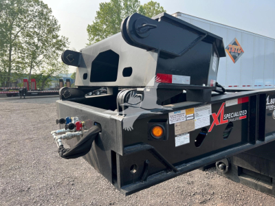 Trailer hitch and rear end of 2024 XL Specialized XL80HDE lowboy trailer showing black steel frame, hydraulic controls, and labeling.