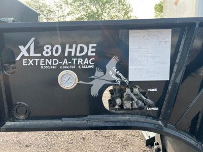 XL80 HDE Extend-A-Trac trailer side panel with gauge, hydraulic control area, and printed specifications.