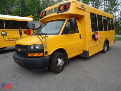 Yellow Chevrolet express micro bird school bus front-right view showing school bus signage and stop sign