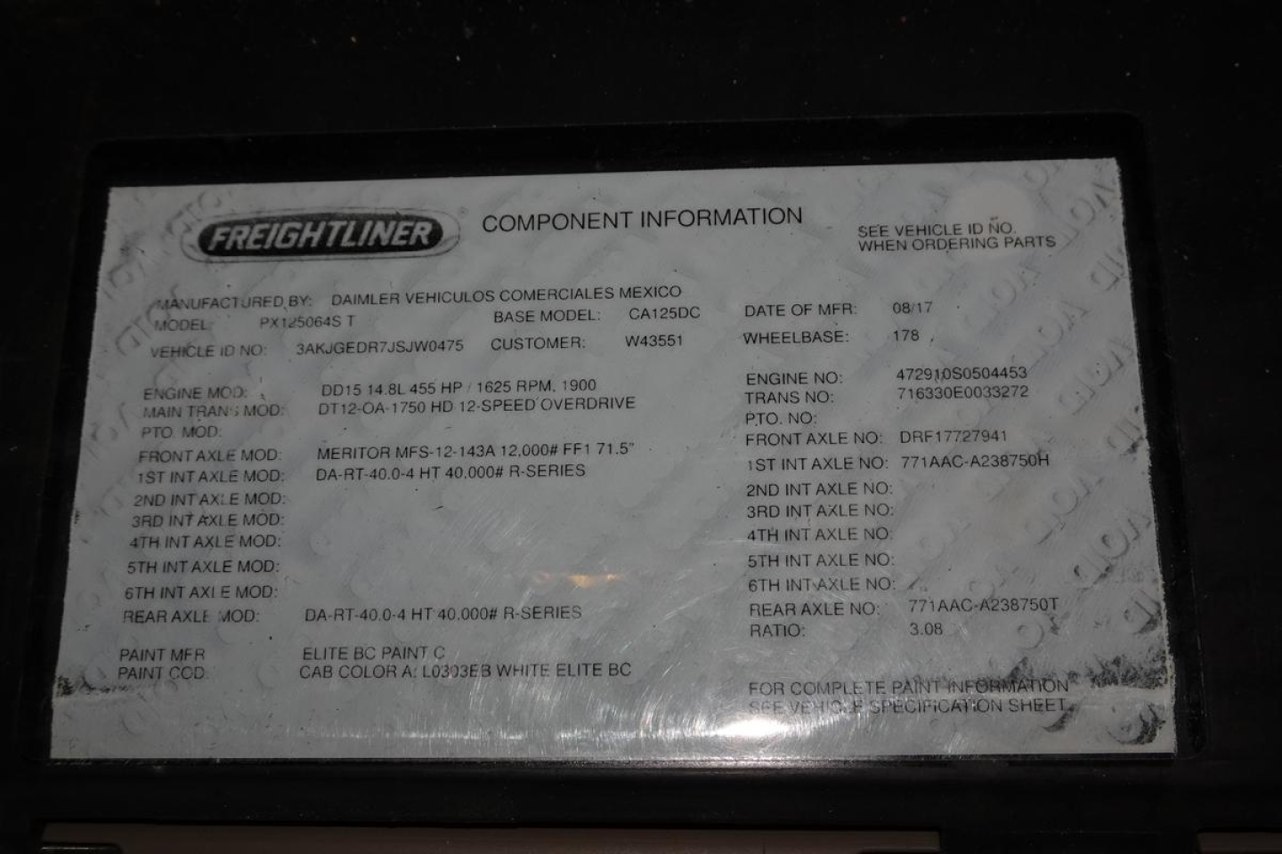 Conventional daycab truck information plate showing model and specifications for Freightliner Cascadia 125. Text includes manufacturer details, base model, engine, and paint info.